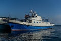 White blue ships boats with stripes on pier in bay of lake baikal in light of sun with reflections in water Royalty Free Stock Photo