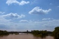 White-blue sky with lamb clouds over the Elbe with a railroad bridge made of iron girders and a branch of the river Royalty Free Stock Photo