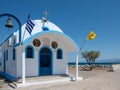 white and blue small church with the Aegean sea and the blue sky at the background