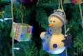 White and Blue Snowman Ornament with Square Shaped Gift Box Hanging on the Sparkling Christmas Tree