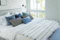 White and blue spacious bedroom with a large bed, in the Scandinavian style.