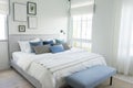 White and blue spacious bedroom with a large bed, in the Scandinavian style.