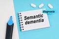 On a white and blue surface are pills, a marker and a notebook with the inscription - Semantic dementia Royalty Free Stock Photo