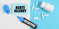 On the white and blue surface are pills, a marker and paper with the inscription - ACUTE ALLERGY Royalty Free Stock Photo