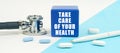 On a white and blue surface are pills, a stethoscope, a pen and a cube with the inscription - Take care of your health Royalty Free Stock Photo