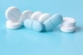 White and blue tablets or pills, medication or drugs. Closeup. Selective focus. Pharmacy, medicine, medical treatment concept Royalty Free Stock Photo