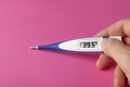 White-blue thermometer with a high temperature of 39.5 degrees Celsius in hand Royalty Free Stock Photo