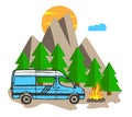 White and blue van with forest and mountains in the background. Living van life, camping in the nature, sitting at fire, travellin