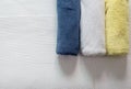 White,Blue,Yellow towel on bed,Stack of plush hotel towels Royalty Free Stock Photo