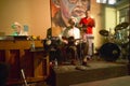 White blues man performing in French Quarter of New Orleans, Louisiana at night on stage playing guitar