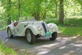 White BMW 328 classic car from 1939 driving on a country road