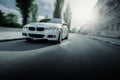 White BMW 3 Series F30 car is driving on asphalt road at summer daytime Royalty Free Stock Photo