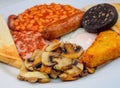 White board with full English breakfast with bacon, fried egg, beans, tomato, roasted sausage, black pudding, scons, hash browns Royalty Free Stock Photo