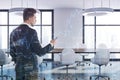 White boardroom room, white chairs side graphs man