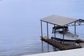 White boat with cabins on the wharf under the roof in the bay on the water