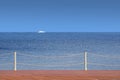 White boat float far on the sea horizon view from the wooden pier in cloudless day