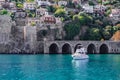 White boat floats in turquoise water against the background of Alanya old town Turkey. Small modern ship on the  background an Royalty Free Stock Photo