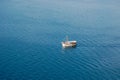 White boat moving on blue tranquil sea from above