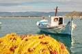 White boat and pile of yellow fishing nets in port Royalty Free Stock Photo