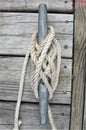 White boat rope knotted around dock cleat Royalty Free Stock Photo