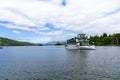 White boat sailing on a tranquil lake, surrounded by lush green trees in Windermere Royalty Free Stock Photo