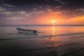 White boat on the sea with an orange-purple sunset sky reflected in the water, Zanzibar, Tanzania Royalty Free Stock Photo