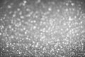 White bokeh lights in the form of snowflakes on a gray silver background. Winter background Royalty Free Stock Photo