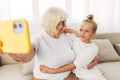 Child togetherness granddaughter grandmother phone smiling sofa family hugging selfie bonding Royalty Free Stock Photo