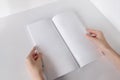 White booklet mockup. Vertical format blank booklet. A woman holds an album with blank pages. Blank cover mocku