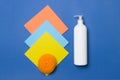 White bottle with cleaning agent, scrubber and napkins on blue colored paper background  top view Royalty Free Stock Photo