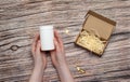 White bottle with omega vitamin pills and cardboard box on wooden background Royalty Free Stock Photo