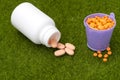 White bottle of orange pills and buckets filled with tablets Royalty Free Stock Photo