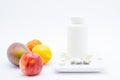 White bottle with pills on scales for food Royalty Free Stock Photo