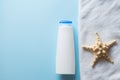 White bottle for shampoo, sea star and towel for bath and spa on blue background. body skin care concept.copy space Royalty Free Stock Photo