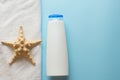 White bottle for shampoo, sea star and towel for bath and spa on blue background. body skin care concept . copy space Royalty Free Stock Photo