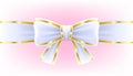 White bow on ribbon with golden edging.