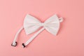 White bow tie on pink background