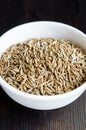 White bowl with aromatic cumin seeds (Cuminum cyminum, Jeera). Close-up, selective focus Royalty Free Stock Photo