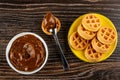 Bowl with boiled condensed milk, spoon with boiled condensed milk on waffle, saucer with soft biscuit waffles on table. Top view Royalty Free Stock Photo