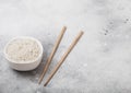 White bowl with boiled organic basmati jasmine rice with wooden chopsticks on white background. Space for text Royalty Free Stock Photo