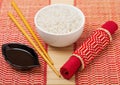 White bowl with boiled organic basmati jasmine rice with wooden chopsticks and sweet soy sauce on bamboo placemat background Royalty Free Stock Photo