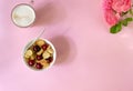 A white bowl of cereal with a tiny pancake with cherries, a cup of cappuccino and flowers on a pink background. Copy space. Top vi Royalty Free Stock Photo