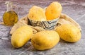 White bowl containing potatoes alongside a glass jar filled with oil on a table Royalty Free Stock Photo