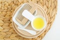 White bowl with cosmetic (massage, cleansing) aroma oil and wooden hairbrush. Natural hair care, homemade spa Royalty Free Stock Photo