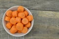 White bowl with cut carrots thick on wooden background Royalty Free Stock Photo