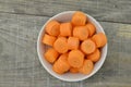 White bowl with cut carrots thick on wooden background Royalty Free Stock Photo