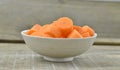 White bowl with cut carrots thick on wooden background Royalty Free Stock Photo