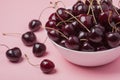 White bowl of fresh red cherries on a pink background. close-up Royalty Free Stock Photo