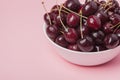 White bowl of fresh red cherries on a pink background. Copy space. close-up Royalty Free Stock Photo