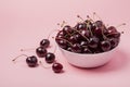 White bowl of fresh red cherries on a pink background. Copy space. close-up Royalty Free Stock Photo